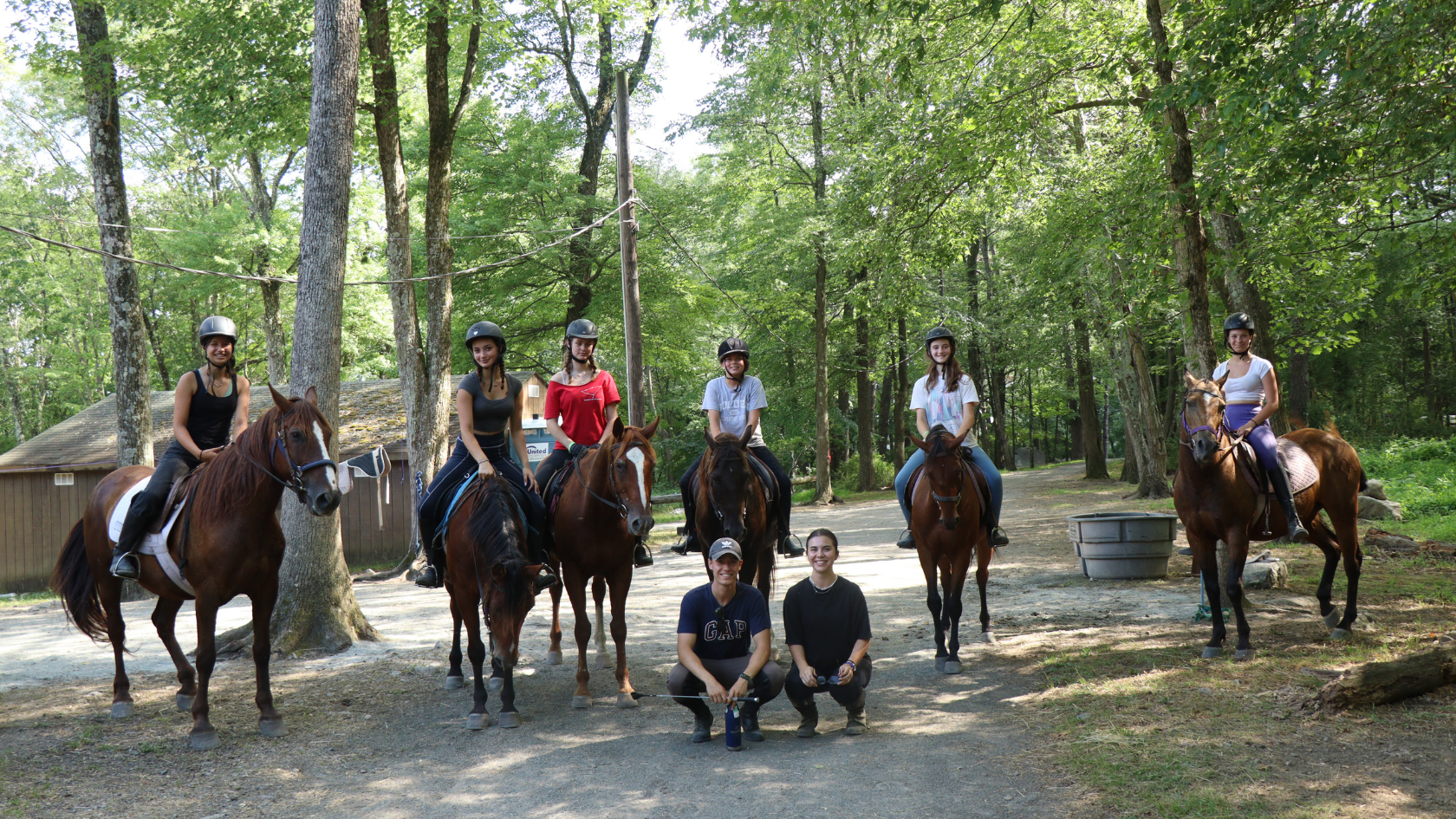 Ranch campers pose on their horses with their instructors