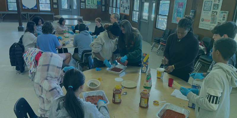 A group of teens making lasagnas for a charity event